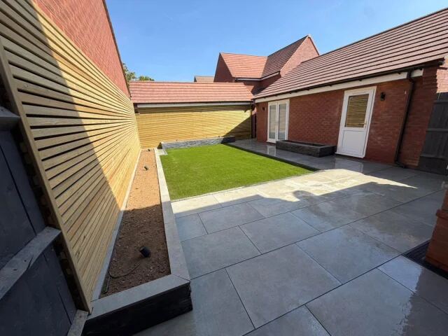 Contemporary porcelain garden with slate planters and Venetian fencing by MAFFS Landscaping